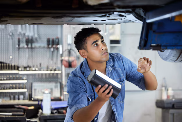 man-mechanic-bottom-car-workshop-working-maintenance-inspection-oil-change-with-light-person-motor-garage-engine-exhaust-diagnostics-transmission-brake-repair
